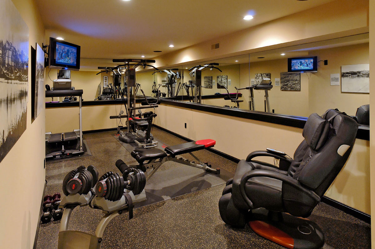 Image of a luxury indoor exercise area showing several types of home gym equipment