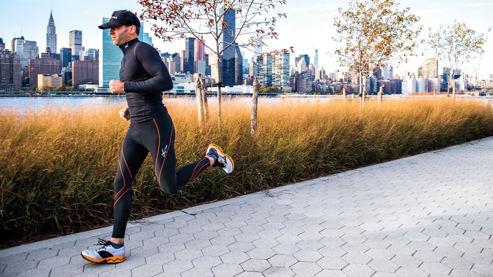 Image of a man running down the sidewalk in compression gear