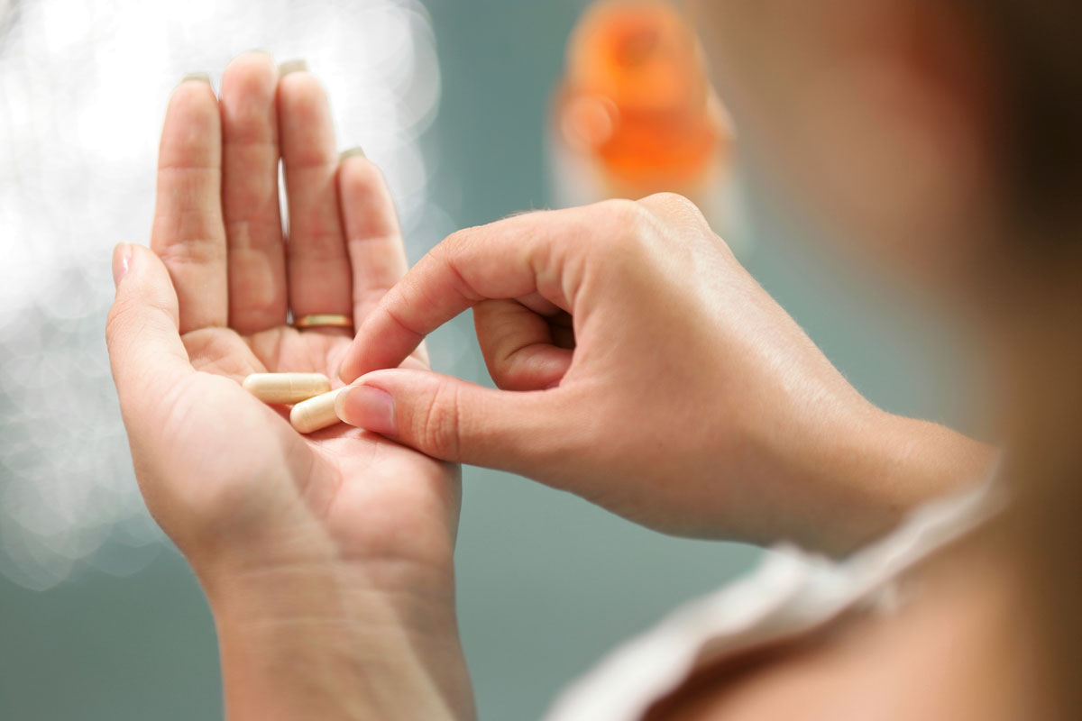 Image of a woman holding collagen supplements
